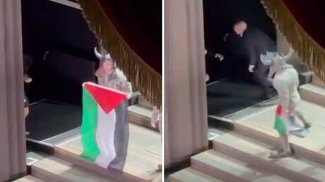 فشلوا في انتزاعه منه.. فنان يرفع علم فلسطين على مسرح دار الأوبرا الملكية في بريطانيا (فيديو)